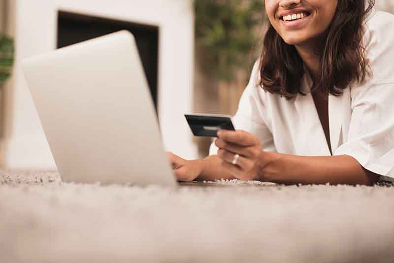 Female hand holding smartphone and credit card to make an online purchase using pay by link